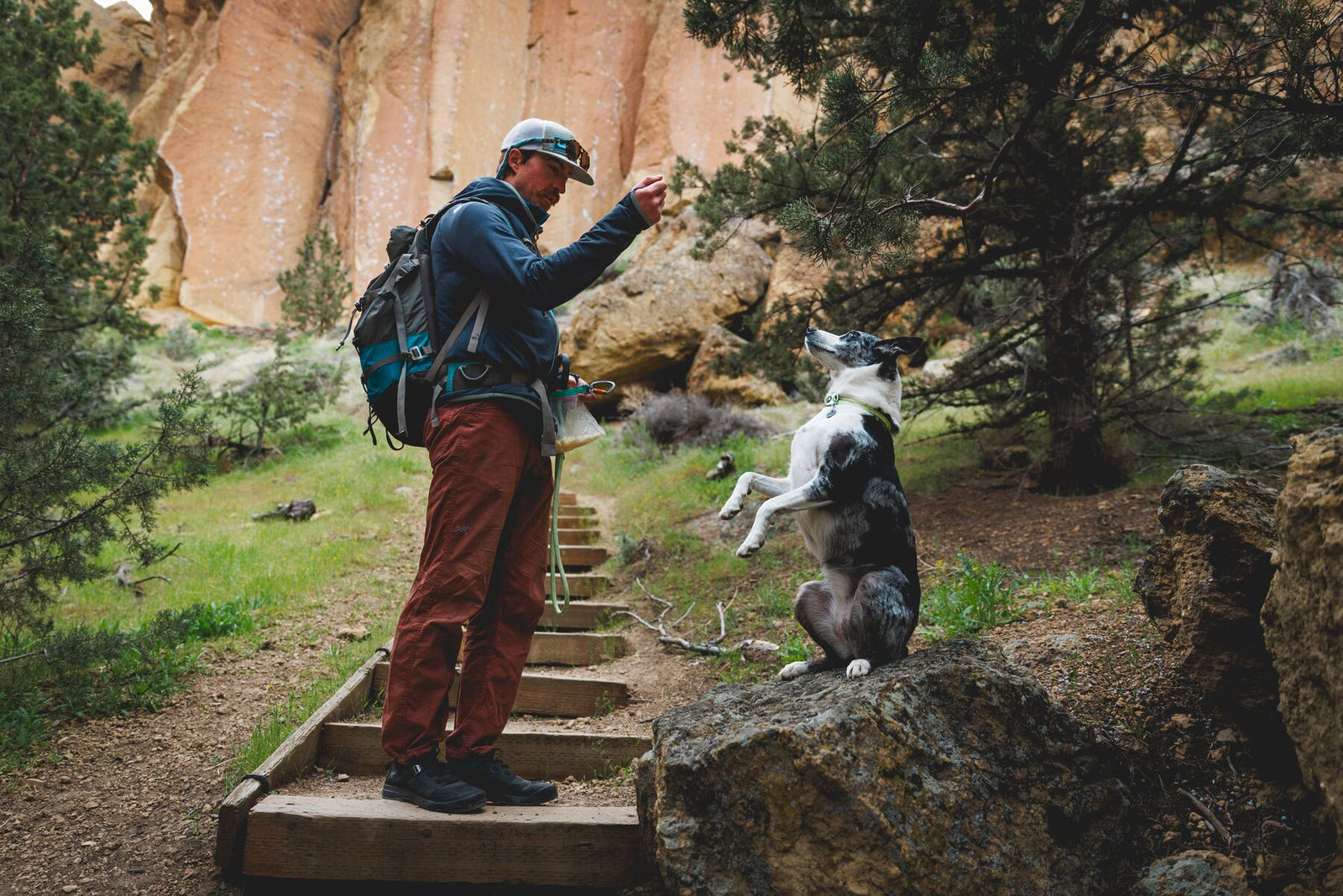 Man and border collie on rocky trail at Smith Rock, Oregon — dog wearing Ruffwear Knot-a-Collar in Moss Green, matching Knot-a-Leash held in hand